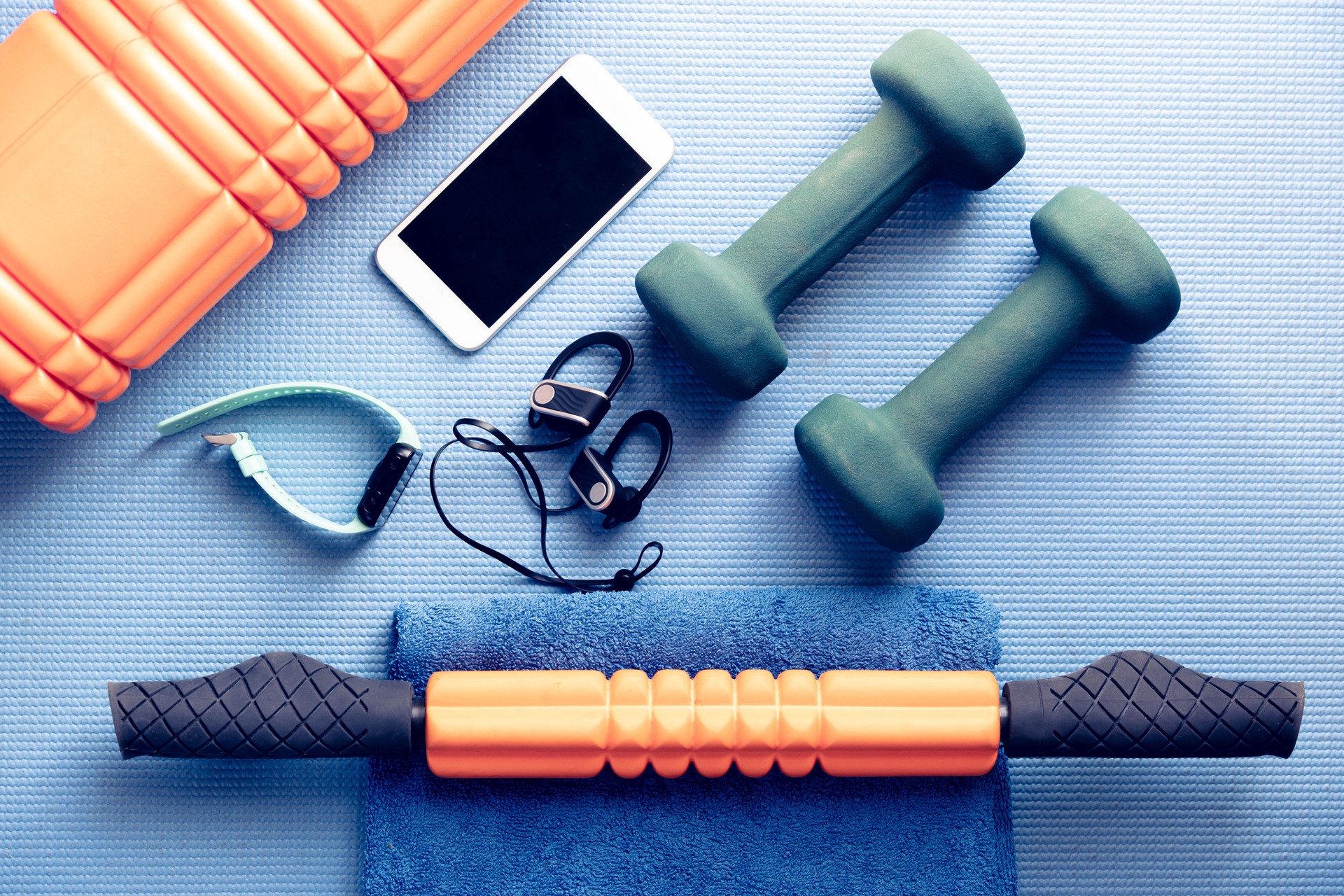 fitness equipment and electronics on a blue yoga mat